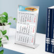 Tischkalender 2026 mit eigenem Logo auf einem Schreibtisch mit Beispiel-Werbeflächendesign.